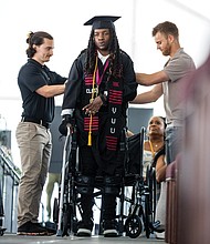 Paralyzed from the chest down after an accident, 22-year-old Jaiden Picot uses advanced robotic technology to walk across the stage and receive his diploma from Virginia Union University’s Sydney Lewis School of Business on Saturday, May 10.