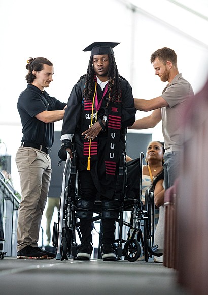 Paralyzed from the chest down after an accident, 22-year-old Jaiden Picot uses advanced robotic technology to walk across the stage and receive his diploma from Virginia Union University’s Sydney Lewis School of Business on Saturday, May 10.