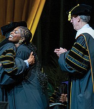 Abigail Akyea embraces presenters on stage after receiving the 2025 Board of Visitors Award at VCU. The award recognizes students who have demonstrated leadership, academic excellence and a commitment to service.
