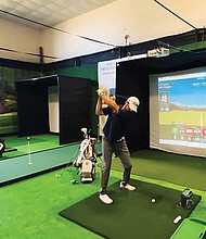 A golfer practices on one of the new simulators at Virginia State University’s Fitness/Wellness Center. The equipment was donated by the PGA to help expand access and diversity in the golf industry.