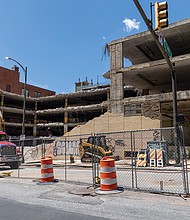 Demolition is underway at a crumbling parking garage at 509 E. Franklin St., forcing the closure of a nearby sidewalk and parking lane.