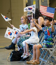 Children wave the Korean and American flags during a performance.