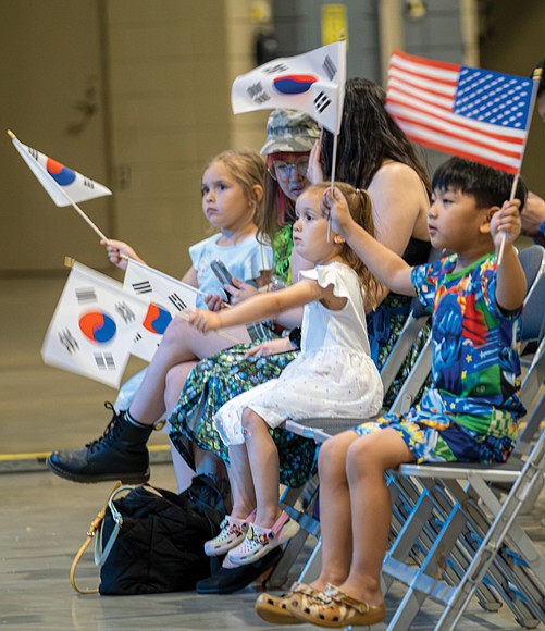 Children wave the Korean and American flags during a performance.