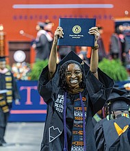 Melana Jacks raises her diploma over her head after graduating from the College of Humanities and Social Sciences at Virginia State University’s spring commencement ceremony May 17 at the VSU Multi-Purpose Center. The university held multiple ceremonies over the weekend to honor graduates from various colleges and programs.