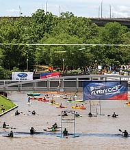 Kayakers take to the water near Browns Island during the Dominion
Energy Riverrock festival, showcasing skills and teamwork in a
variety of races and challenges.