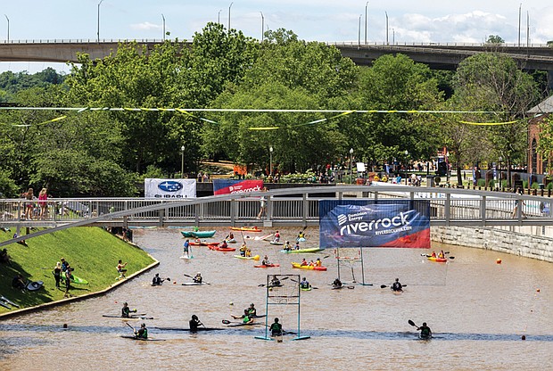 Kayakers take to the water near Browns Island during the Dominion
Energy Riverrock festival, showcasing skills and teamwork in a
variety of races and challenges.