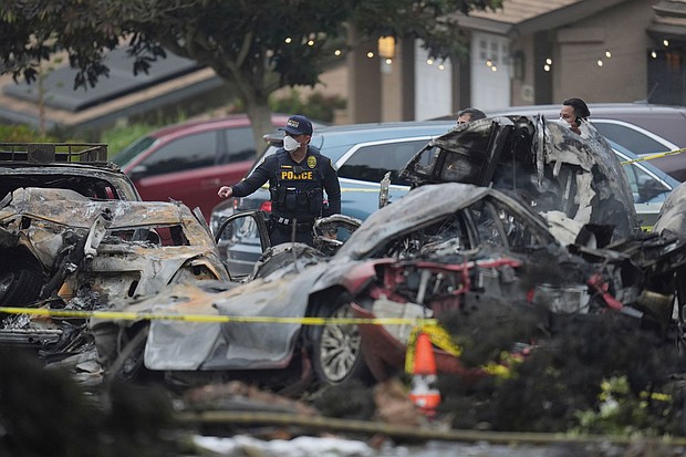 Authorities work the scene where a small plane crashed into a San Diego neighborhood early Thursday.
Mandatory Credit:	Gregory Bull/AP via CNN Newsource