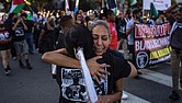 People embrace while attending a march remembering George Floyd on Wednesday, May 21, in Los Angeles.