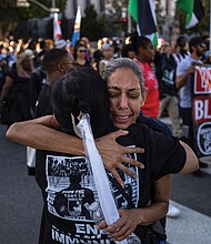 People embrace while attending a march remembering George Floyd on Wednesday, May 21, in Los Angeles.