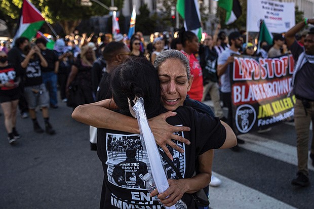 People embrace while attending a march remembering George Floyd on Wednesday, May 21, in Los Angeles.