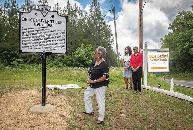 Gayle Turner, a member of the Tucker family, stands beside the newly unveiled highway marker honoring Bruce Tucker. In 1968, Tucker’s heart was removed without his family’s consent and transplanted into a white man, marking Virginia’s first heart transplant and the 16th in the world.