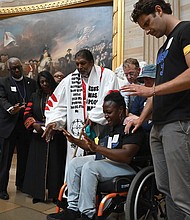 Suvya Carroll, seated, and others pray in the U.S. Capitol Rotunda, Monday, June 2, 2025, in Washington.
