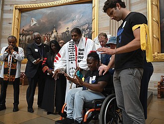 Suvya Carroll, seated, and others pray in the U.S. Capitol Rotunda, Monday, June 2, 2025, in Washington.