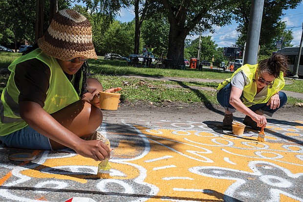Richmond residents Alexis Fryar and Kathryn Settle contribute to a community mural at the
intersection of Hermitage and Laburnum during a volunteer paint day. The collaborative artwork
is part of a traffic calming initiative aimed at enhancing pedestrian and cyclist safety in the area
surrounding Linwood Holton Elementary School.
