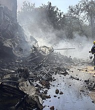 Firefighters work at the site of an airplane that crashed in India's northwestern city of Ahmedabad in Gujarat state, on Thursday,  June12.
Mandatory Credit:	Ajit Solanki/AP via CNN Newsource