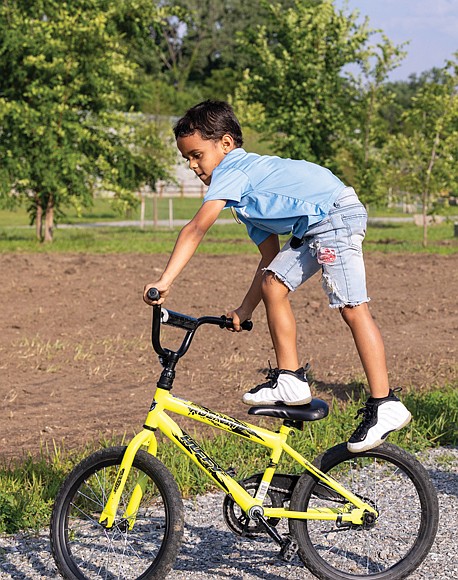 Amarii Clayton, 7, rides his bike in Dock Street Park on Saturday, May 31. Warmer temperatures are expected this week as summer returns to the region.