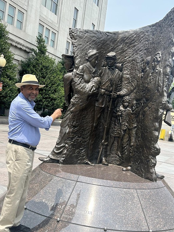 Dr. Frank Smith, founder and executive director of the African American Civil War Memorial and Museum, stands next to the …