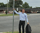 Jon Lugbill stands next to the new street sign for Honorary Jon Lugbill Drive outside the Sports Backers headquarters in Henrico County. Lugbill is retiring this month after 32 years as executive director.