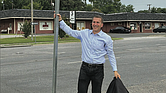 Jon Lugbill stands next to the new street sign for Honorary Jon Lugbill Drive outside the Sports Backers headquarters in Henrico County. Lugbill is retiring this month after 32 years as executive director.