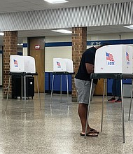 A voter participates in the Democratic primary at Hermitage High School amid growing discussions in Virginia about joining a nationwide movement to decide presidential elections by the popular vote.