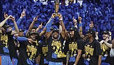 Oklahoma City Thunder guard Shai Gilgeous-Alexander, center, holds up the MVP trophy as he celebrates with his team after they won the NBA basketball championship with a Game 7 victory against the Indiana Pacers Sunday, June 22, in Oklahoma City.