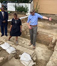 From left, Reginald F. Davis, pastor of First Baptist Church, Connie Matthews Harshaw, a member of First Baptist and Jack Gary, Colonial Williamsburg’s director of archaeology, stand at the foundation of one the oldest Black churches in the U.S. in 2021, in Williamsburg.