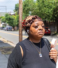 Quatice Scott fans herself while walking through the Fan District on a 98-degree day Monday, June 23, with little breeze to offer relief.
