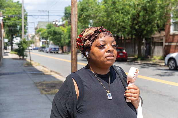 Quatice Scott fans herself while walking through the Fan District on a 98-degree day Monday, June 23, with little breeze to offer relief.
