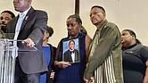 Vivian Sterling, center, and William Peoples stand with a photo of their son, Jabari Peoples, as attorney Ben Crump, far left, speaks to reporters during a press conference in Homewood, Ala., Tuesday, July 8, 2025.
