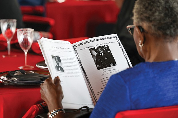 A guest reads the program during the ceremony. The firefighters’ hiring on July 1, 1950, marked a significant step forward in the struggle for civil rights.