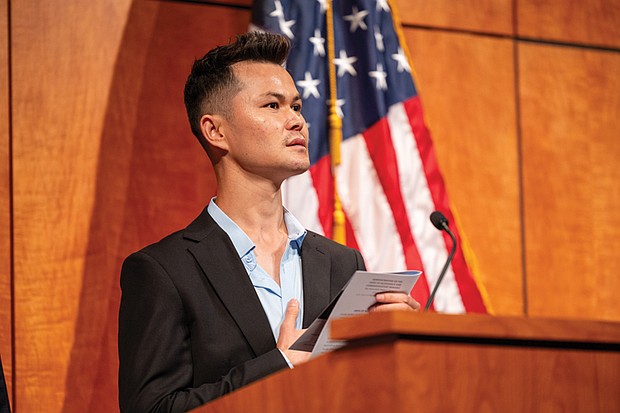 Burhan Hussaini, originally from Afghanistan, leads the Pledge of Allegiance during a naturalization ceremony Friday, July 4, at the Virginia Museum of History & Culture, where he and dozens of others received their U.S. citizenship.