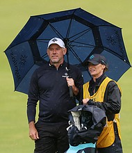 Lee Westwood interacts with his wife and caddie Helen Storey on the 18th green during day one of The 153rd Open Championship at Royal Portrush.
Mandatory Credit:	Andrew Redington/Getty Images via CNN Newsource