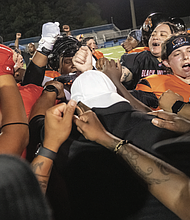Coaches and players celebrate after the game.