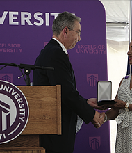 Excelsior University President David Schejbal presents the university’s President’s Medal posthumously to Lt. Gen. Arthur J. Gregg, accepting on his behalf is his daughter, Alicia Collier.