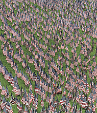 More than 12,000 American flags blanketed the hillside at the Virginia War Memorial through July 11 as part of the Hill of Heroes tribute, honoring the Virginians who died in military service since World War II. Volunteers gathered that morning to remove the display.