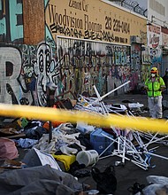 A worker stands on a corner during a street cleaning operation in Skid Row Los Angeles, California, U.S., December 9, 2024.
Mandatory Credit:	Daniel Cole/Reuters via CNN Newsource