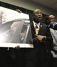 William McNeil Jr.’s attorney Ben Crump, center, speaks while showing a still from a police body cam video during a press conference Tuesday, July 29, 2025, in Chicago.