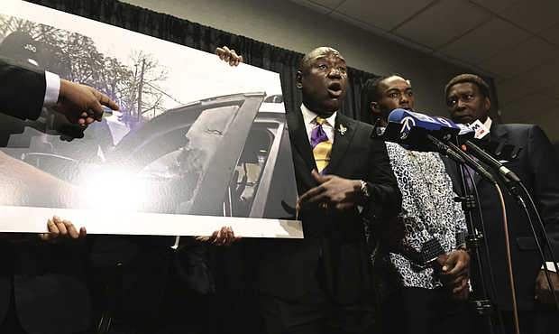 William McNeil Jr.’s attorney Ben Crump, center, speaks while showing a still from a police body cam video during a press conference Tuesday, July 29, 2025, in Chicago.