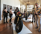 A visitor checks out a custom motorcycle on display at the “Ruined + Refined” exhibition, featuring unique builds and Vespa scooters. The exhibitions continue through Aug. 31.