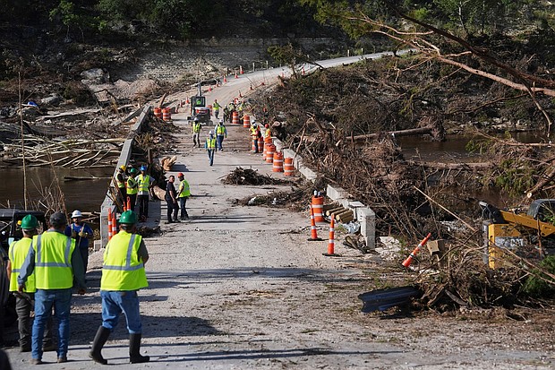 Crews work to clear debris July 10 on the Cade Loop Bridge after flooding along the Guadalupe River in Ingram, Texas.
Mandatory Credit:	Joshua A. Bickel/AP via CNN Newsource
Dateline:	INGRAM, T