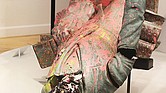 The Jefferson Davis statue, erected in 1907 on Monument Avenue and pulled down by protesters on June 10, 2020, is shown as part of a temporary exhibit at The Valentine. The former Confederate leader appears splattered with pink paint, with a blackened face and a dent on the back of the head from the 2020 protest.
