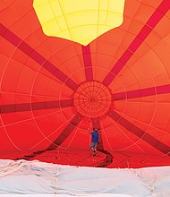 A team of current and former firefighters prepares a hot air balloon shaped like Tiny the Fire Dog. The balloon honors retired Henrico Deputy Fire Chief R.C. “Tiny” Dawson and pays tribute to fallen emergency personnel.