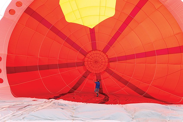 A team of current and former firefighters prepares a hot air balloon shaped like Tiny the Fire Dog. The balloon honors retired Henrico Deputy Fire Chief R.C. “Tiny” Dawson and pays tribute to fallen emergency personnel.