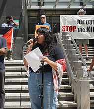 Virginia Defenders member Fernanda Diaz-Castro, center, addresses the crowd during a Monday afternoon rally at City Hall, where attendees called for a ban on cooperation with ICE.