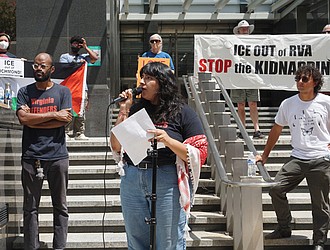 Virginia Defenders member Fernanda Diaz-Castro, center, addresses the crowd during a Monday afternoon rally at City Hall, where attendees called for a ban on cooperation with ICE.