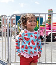 Josefina Fuentes 2 dressed for the occasion in the kids area with carnival rides at the 43rd Annual Carytown Watermelon Festival in Carytown on Sunday Aug 10. The event filled Cary Street with more than 100 vendors and artisans selling everything from crafts and teas to food, cups of fresh watermelon, and watermelon-flavored treats and drinks. The event featured live music across five stages, with additional small entertainment acts scattered throughout the street. Activities for all ages included face painting, a children’s area, and carnival rides.