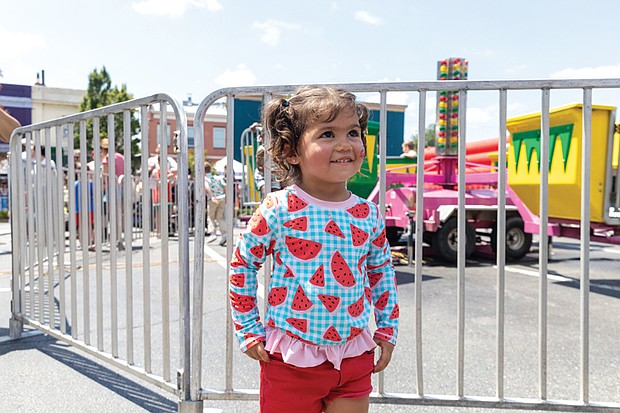 Josefina Fuentes 2 dressed for the occasion in the kids area with carnival rides at the 43rd Annual Carytown Watermelon Festival in Carytown on Sunday Aug 10. The event filled Cary Street with more than 100 vendors and artisans selling everything from crafts and teas to food, cups of fresh watermelon, and watermelon-flavored treats and drinks. The event featured live music across five stages, with additional small entertainment acts scattered throughout the street. Activities for all ages included face painting, a children’s area, and carnival rides.