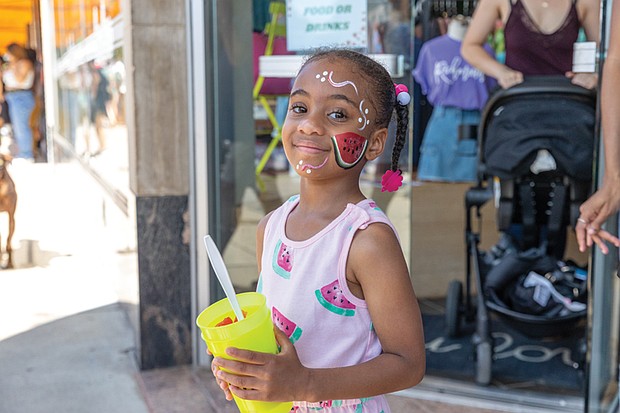 Moriya, 6, dressed for the occasion, enjoys a cup of watermelon at the 43rd Annual Carytown Watermelon Festival in Carytown on Sunday Aug 10. The event filled Cary Street with more than 100 vendors and artisans selling everything from crafts and teas to food, cups of fresh watermelon, and watermelon-flavored treats and drinks. The event featured live music across five stages, with additional small entertainment acts scattered throughout the street. Activities for all ages included face painting, a children’s area, and carnival rides.
