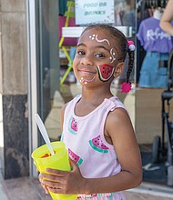 Moriya, 6, dressed for the occasion, enjoys a cup of watermelon at the 43rd Annual Carytown Watermelon Festival in Carytown on Sunday Aug 10. The event filled Cary Street with more than 100 vendors and artisans selling everything from crafts and teas to food, cups of fresh watermelon, and watermelon-flavored treats and drinks. The event featured live music across five stages, with additional small entertainment acts scattered throughout the street. Activities for all ages included face painting, a children’s area, and carnival rides.