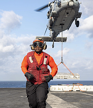 Aviation Ordnanceman 3rd Class Jader Jamecia, a native of Houston, takes position as an MH-60S Sea Hawk helicopter, assigned to the "Dragonslayers" of Helicopter Sea Combat Squadron (HSC) 11, transports ordnance to the Lewis and Clark-class supply ship USNS Robert E. Peary (T-AKE 5) from the flight deck of the Nimitz-class aircraft carrier USS Harry S. Truman (CVN 75) during an ammunition offload. Truman is currently underway in the Atlantic Ocean. (Photo by Mass Communication Specialist 2nd Class Logan McGuire)
